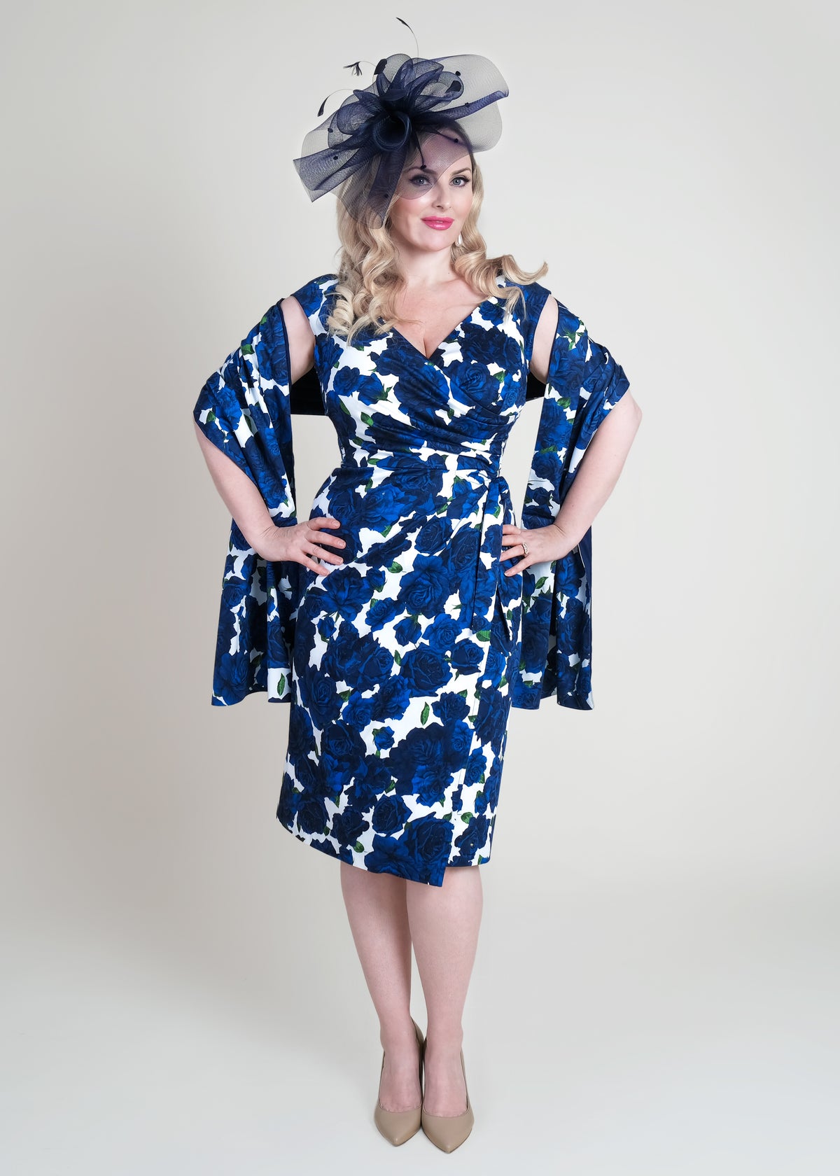 Bombshell blue and white floral dress with elegant fascinator, stylish mid-length pencil dress for special occasion, chic women's fashion.